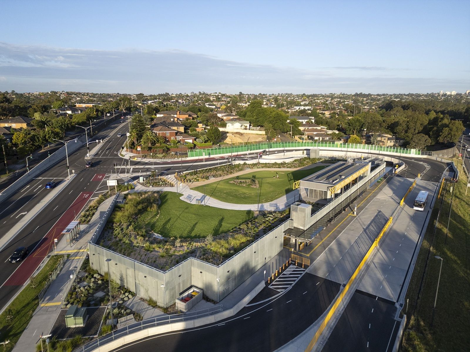 Aerial photo of a new bus interchange with its access roads, kerbs and retaining walls beside an arterial road